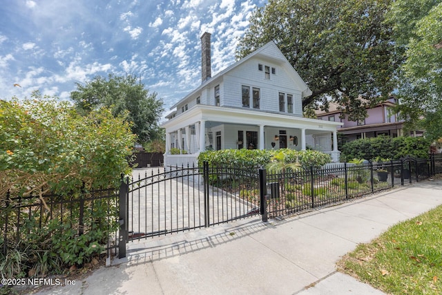 view of front of property with a fenced front yard, a chimney, and a porch