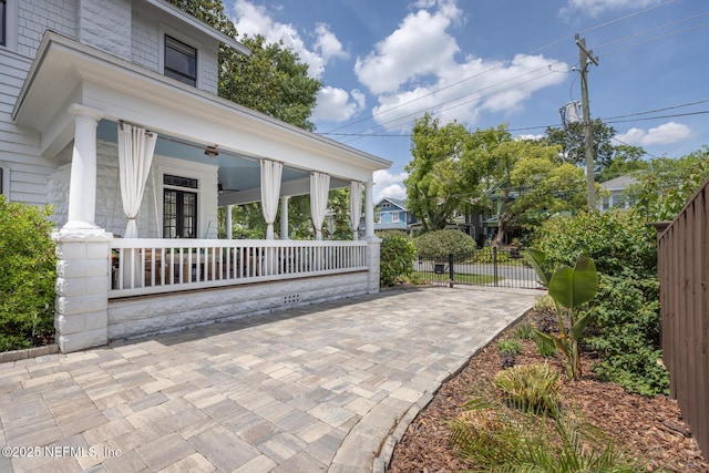 exterior space featuring a porch, fence, and french doors