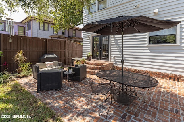 view of patio / terrace featuring fence, french doors, an outdoor hangout area, and entry steps