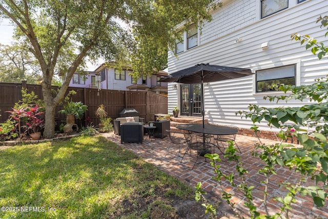 view of yard with an outdoor living space, french doors, a fenced backyard, and a patio area