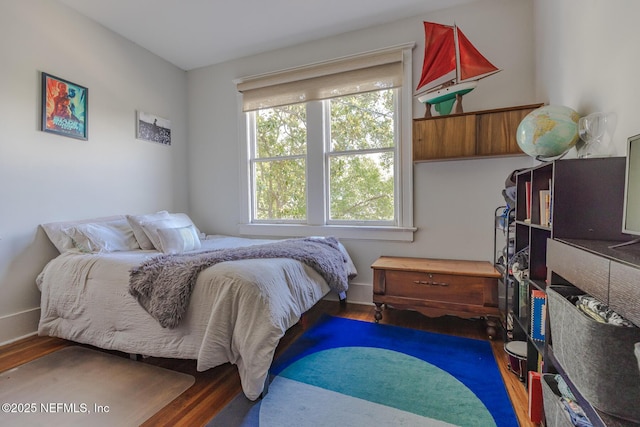 bedroom featuring baseboards and wood finished floors