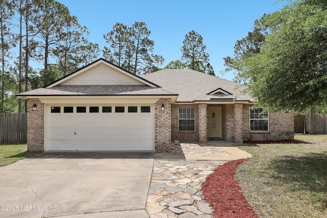 11009 Fawnwood Ct, Bryceville, FL 32009 - ranch-style house with brick siding, fence, roof with shingles, concrete driveway, and an attached garage
