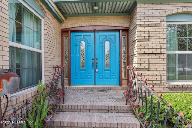 view of exterior entry with brick siding