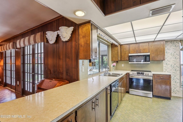 kitchen featuring a sink, visible vents, stainless steel appliances, light countertops, and backsplash