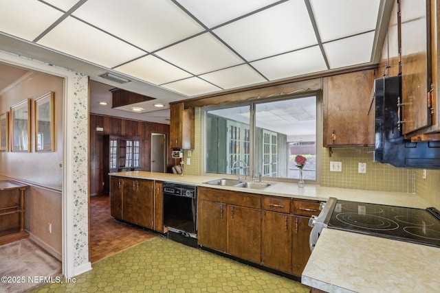 kitchen featuring a sink, black dishwasher, light countertops, tasteful backsplash, and baseboards