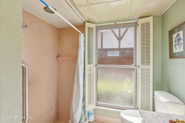 full bath featuring toilet and tiled shower