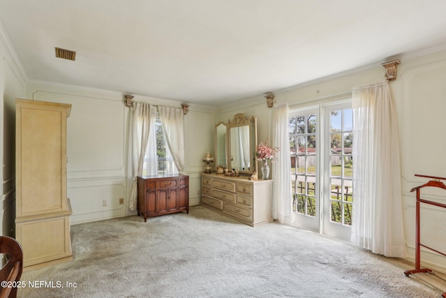 bedroom featuring ornamental molding, multiple windows, light colored carpet, and visible vents