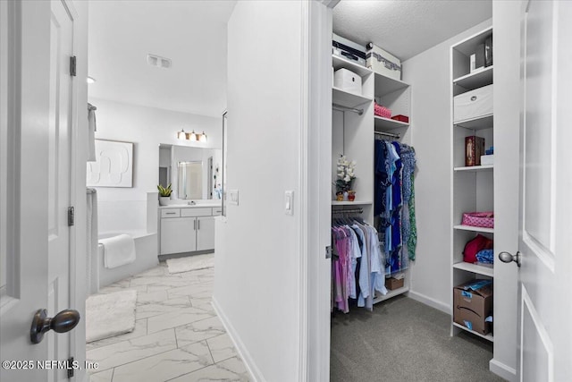 spacious closet featuring marble finish floor and visible vents