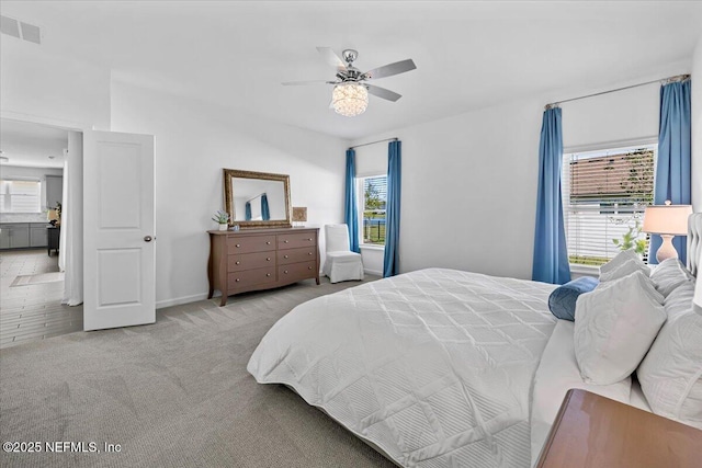 carpeted bedroom with visible vents, baseboards, and ceiling fan
