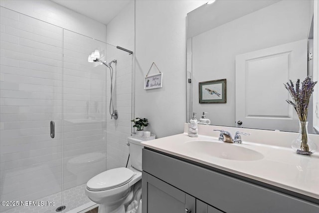 full bathroom with a shower stall, toilet, and vanity