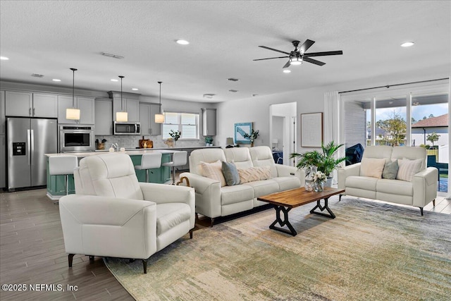 living room with a wealth of natural light, recessed lighting, and ceiling fan