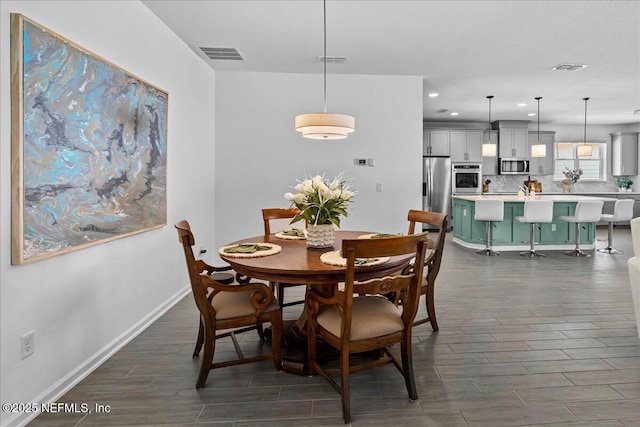dining room featuring dark wood-type flooring, visible vents, baseboards, and recessed lighting