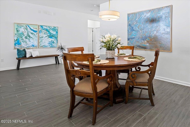 dining space with baseboards and dark wood-style flooring
