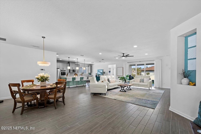 living area featuring baseboards, dark wood-style floors, recessed lighting, and ceiling fan