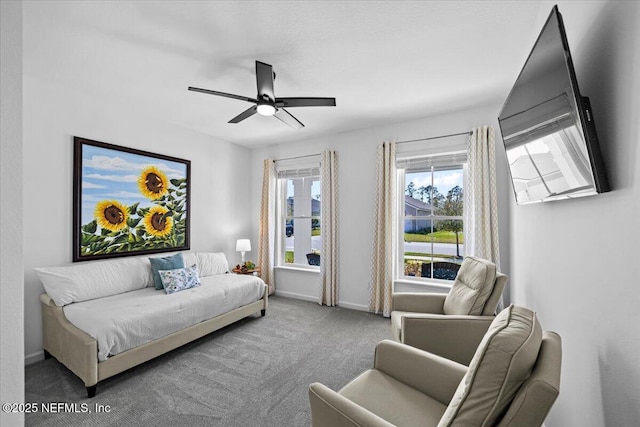 carpeted living room with a ceiling fan and baseboards