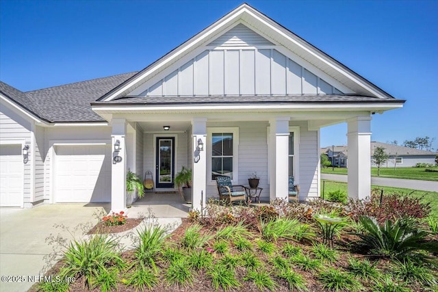 view of front facade featuring driveway, board and batten siding, a shingled roof, an attached garage, and a porch