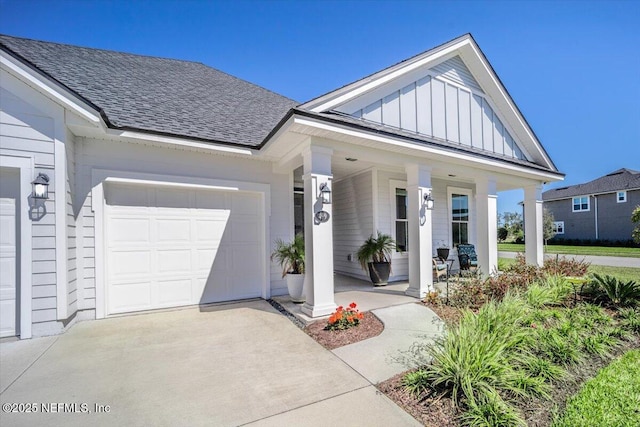 view of front of home featuring driveway, board and batten siding, a shingled roof, covered porch, and an attached garage