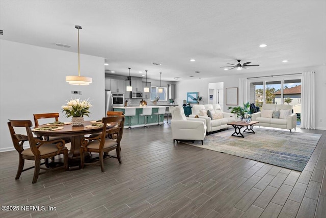 living room featuring plenty of natural light, ceiling fan, dark wood-style floors, and recessed lighting