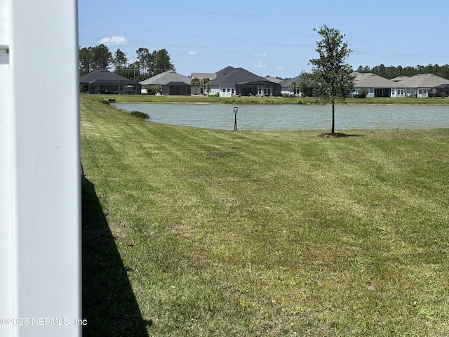 view of yard featuring a water view and a residential view