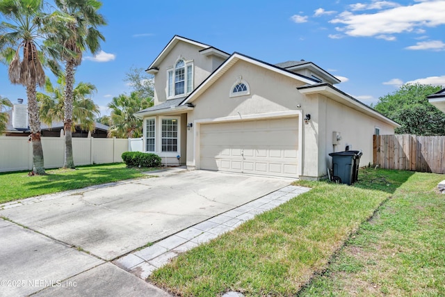 traditional-style house featuring a front lawn, a garage, driveway, stucco siding, and fence