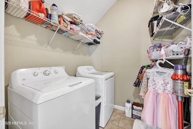 laundry room with light tile patterned floors, washer and dryer, laundry area, and baseboards