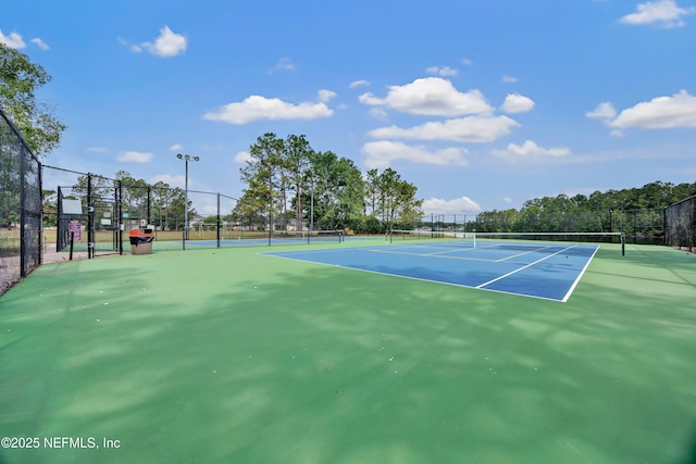 view of tennis court featuring fence