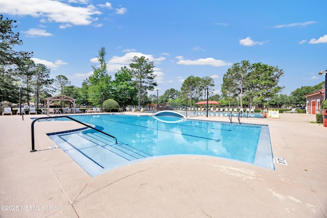 community pool featuring a patio, a gazebo, and fence