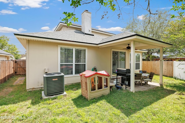 back of house with a lawn, central AC, a fenced backyard, and a patio area