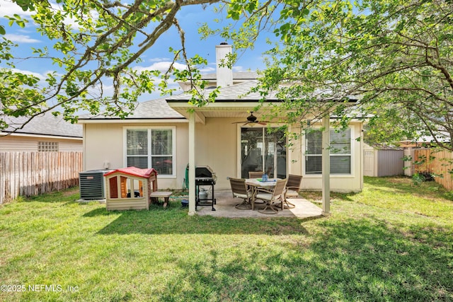back of property featuring a patio, a shingled roof, ceiling fan, a fenced backyard, and a lawn
