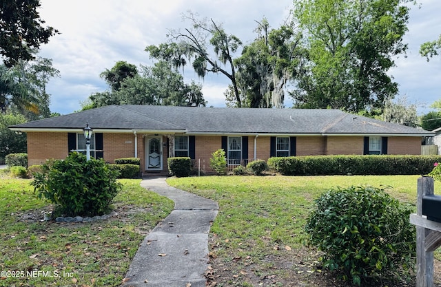3715 Rustic Ln, Jacksonville, FL 32217 - ranch-style house with brick siding, a front yard, and roof with shingles