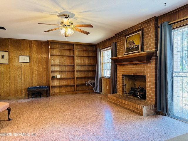 3715 Rustic Ln, Jacksonville, FL 32217 - unfurnished living room featuring wood walls, plenty of natural light, ceiling fan, and a brick fireplace