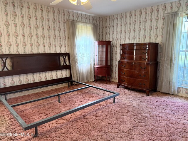 3715 Rustic Ln, Jacksonville, FL 32217 - carpeted bedroom featuring wallpapered walls, multiple windows, and a ceiling fan