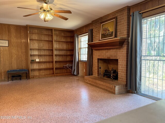 3715 Rustic Ln, Jacksonville, FL 32217 - unfurnished living room with wooden walls, ceiling fan, a fireplace, and built in shelves