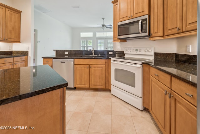 3099 Five Oaks Ln, Green Cove Springs, FL 32043 - kitchen featuring appliances with stainless steel finishes, a sink, a ceiling fan, and dark stone countertops