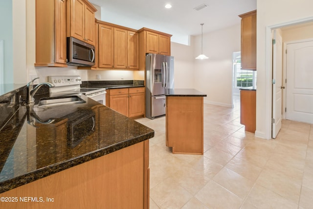 3099 Five Oaks Ln, Green Cove Springs, FL 32043 - kitchen featuring appliances with stainless steel finishes, a sink, a kitchen island, brown cabinets, and decorative light fixtures