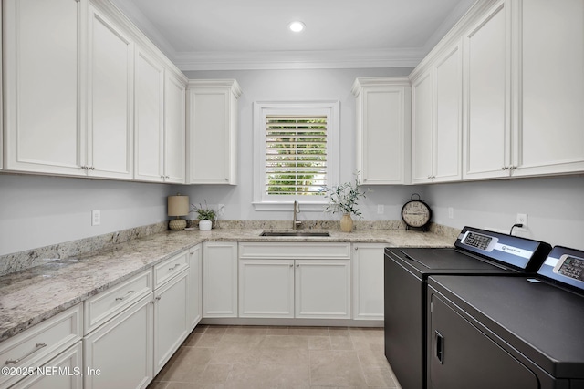 washroom featuring cabinet space, a sink, washing machine and dryer, recessed lighting, and ornamental molding