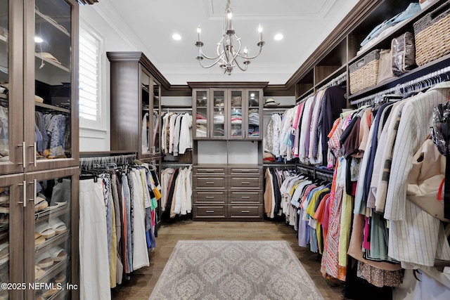 walk in closet featuring a chandelier