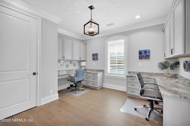 home office featuring light wood-style floors, crown molding, baseboards, and built in desk