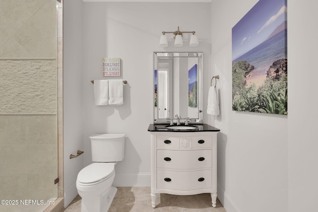 full bath with tile patterned flooring, vanity, toilet, baseboards, and tiled shower