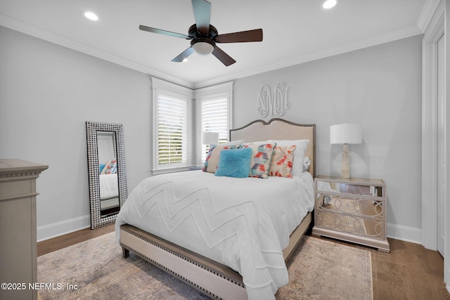 bedroom with baseboards, ornamental molding, and wood finished floors