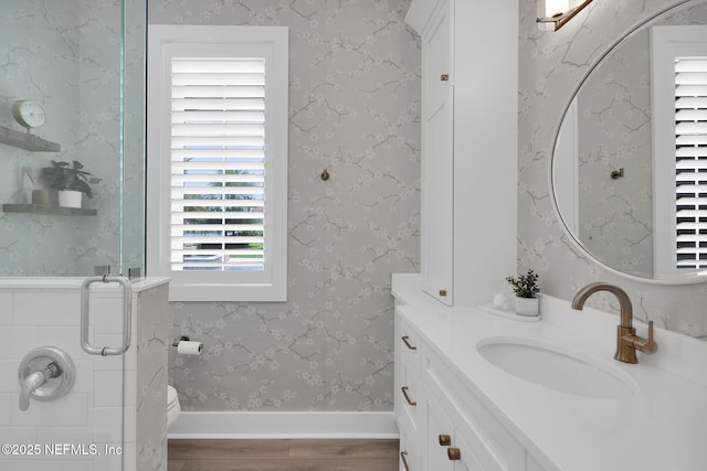 full bath with vanity, toilet, wood finished floors, and a stall shower