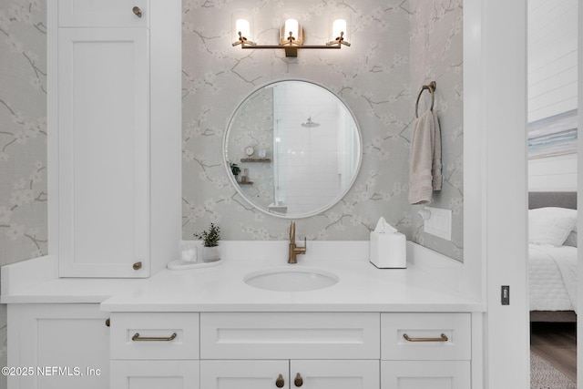 ensuite bathroom featuring vanity, wallpapered walls, and connected bathroom