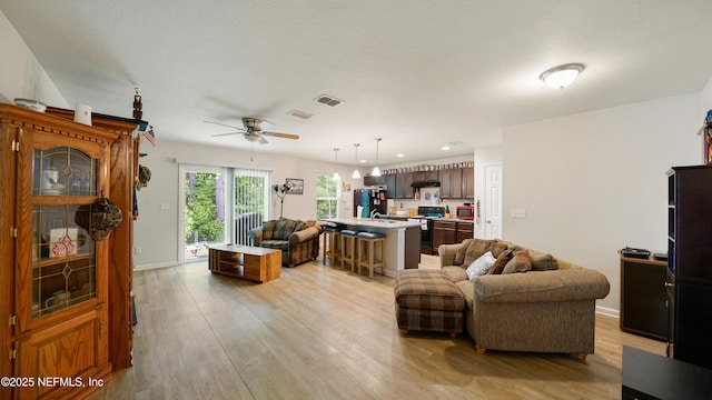 living area featuring visible vents, a ceiling fan, light wood-style floors, and recessed lighting