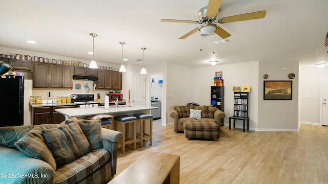 living area featuring visible vents, light wood-style flooring, ceiling fan, and baseboards