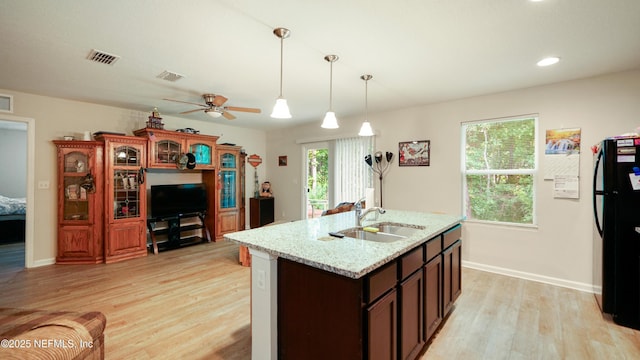 kitchen featuring ceiling fan, a sink, freestanding refrigerator, light wood-type flooring, and pendant lighting