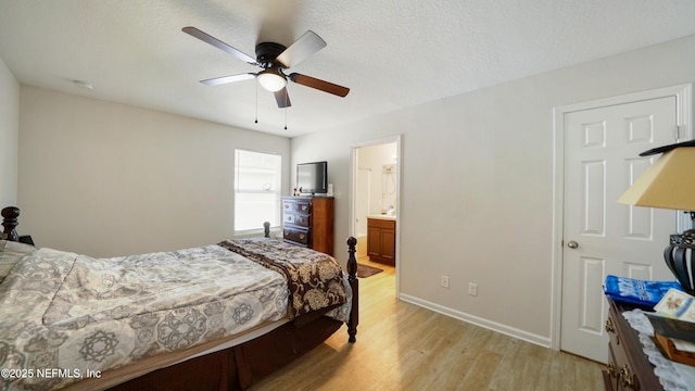 bedroom featuring connected bathroom, a ceiling fan, baseboards, and light wood-style flooring