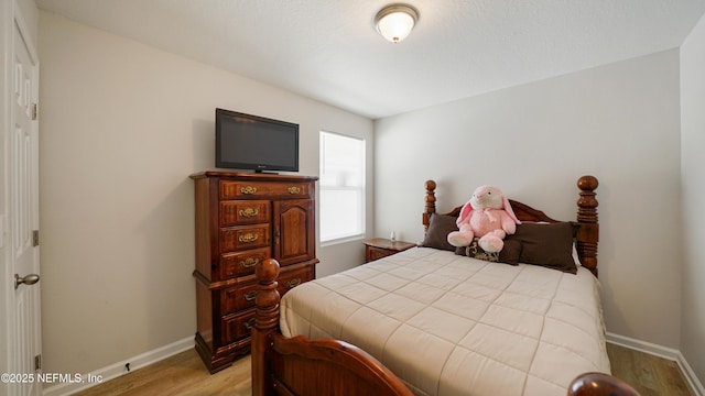 bedroom featuring baseboards and light wood-type flooring