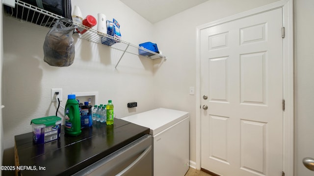 clothes washing area with washing machine and clothes dryer and laundry area