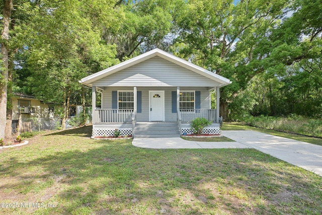 bungalow-style house featuring a porch, a front lawn, and fence