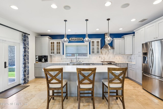 1833 N Lakeshore Dr, Fleming Island, FL 32003 - kitchen with wall chimney range hood, appliances with stainless steel finishes, a sink, a center island, and tasteful backsplash